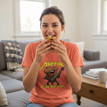 Woman wearing a t-shirt with a muffin graphic and text, holding a muffin in a living room.
