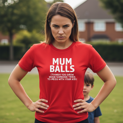 Woman wearing a red t-shirt with 'MUM BALLS' text in a grassy outdoor setting.