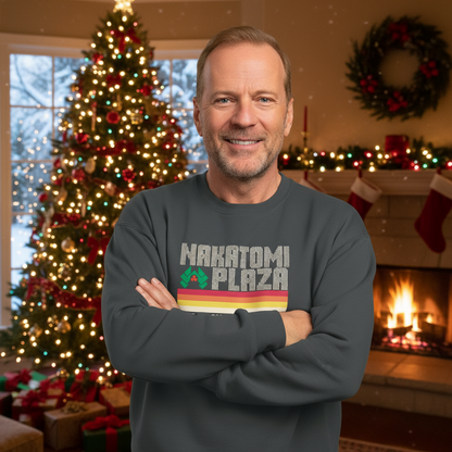 Man wearing a 'Nakatomi Plaza' sweatshirt in a festive room with Christmas tree and fireplace.