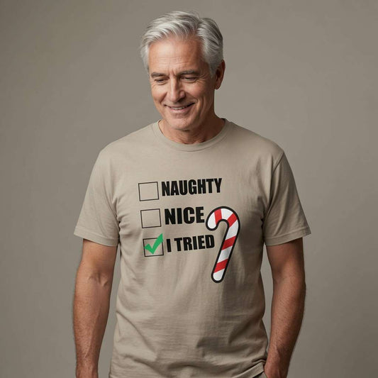 Man with grey hair smiling looking down in beige Naughty Nice I Tried t-shirt with candy cane, funny witty mens christmas party banter