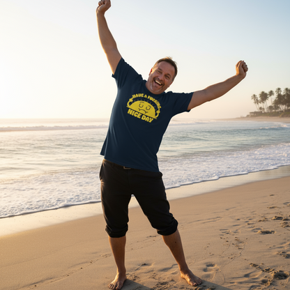 Man on a beach with arms raised, wearing a blue t-shirt with yellow text.