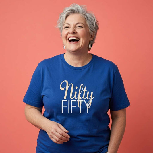 Woman laughing with one hand near her waist while wearing a blue Nifty Fifty t-shirt, fun ladies 50th birthday slogan gift design full of pure attitude