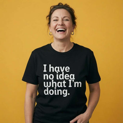 Woman laughing with one hand near her hip while wearing a black I Have No Idea What I’m Doing t-shirt, funny ladies witty slogan design that every no-nonsense lady will claim