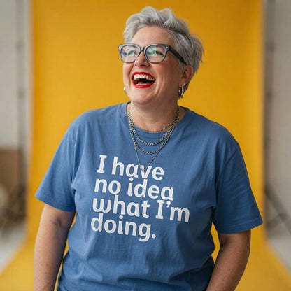 Woman laughing with layered necklaces while wearing a blue I Have No Idea What I’m Doing t-shirt, humorous ladies cheeky slogan design full of pure attitude