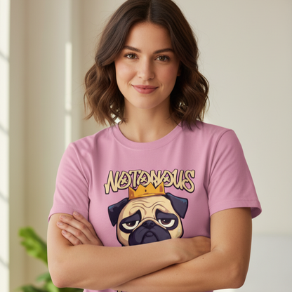 Woman wearing a pink t-shirt with a graphic of a pug and text, standing indoors.