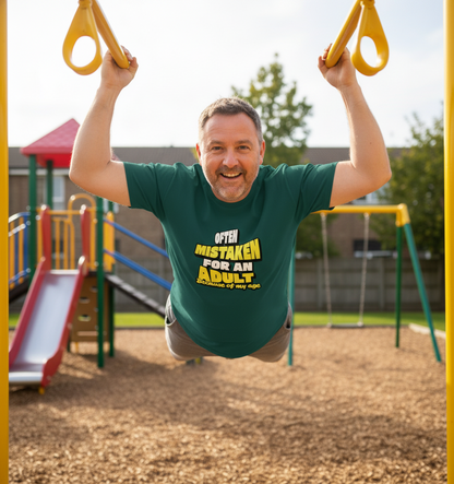Man swinging on playground equipment wearing a green t-shirt with humorous text.