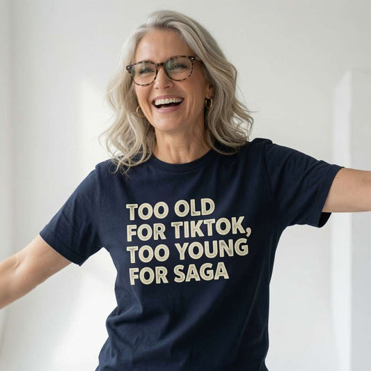 Woman laughing with arms outstretched in a navy Too Old For TikTok, Too Young For Saga t-shirt, fun and cheeky age banter full of personality