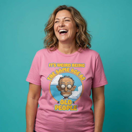 Woman laughing while wearing a pink It’s Weird Being The Same Age As Old People t-shirt, witty ladies funny old banter graphic design full of pure attitude