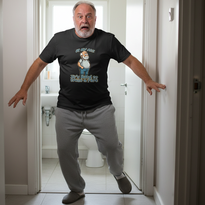 Man in a bathroom wearing a black t-shirt with a graphic design.