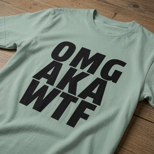 Green OMG AKA WTF t-shirt laid flat on a wooden surface showing the bold black text, funny ladies relatable witty slogan design that every no-nonsense lady will claim