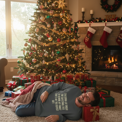 Man lying on the floor in front of a decorated Christmas tree with presents and stockings.