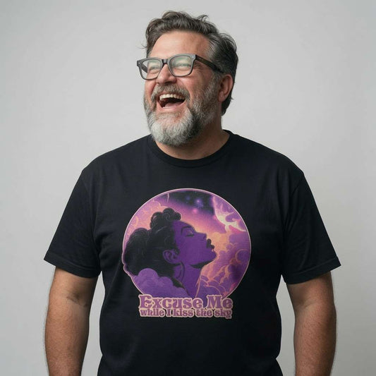 Bearded man with glasses laughing in a black Excuse Me While I Kiss the Sky t-shirt, mens 70s music-inspired graphic full of pure psychedelic energy