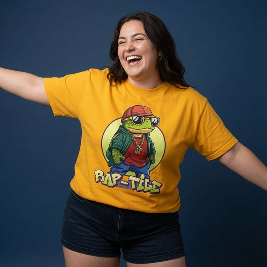 Woman laughing with arms outstretched while wearing a yellow Rap-Tile t-shirt featuring a cool turtle in a red cap, sunglasses and gold chain, witty ladies good vibe turtle pun graphic