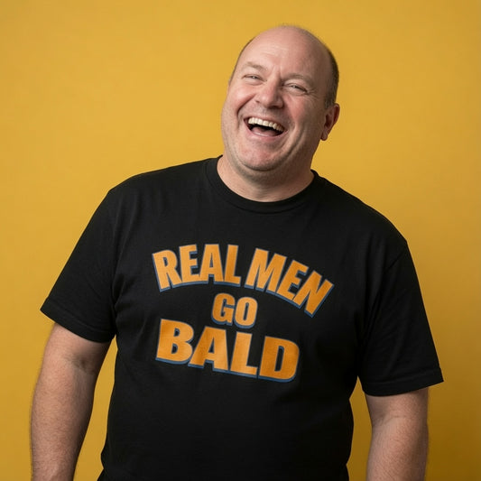Man laughing while wearing a black Real Men Go Bald t-shirt, funny mens witty baldy slogan design full of pure attitude