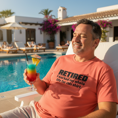 Man in a 'Retired' shirt holding a colorful drink by a poolside.