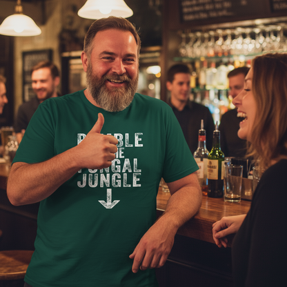 Man in a bar giving a thumbs up wearing a green t-shirt with text.
