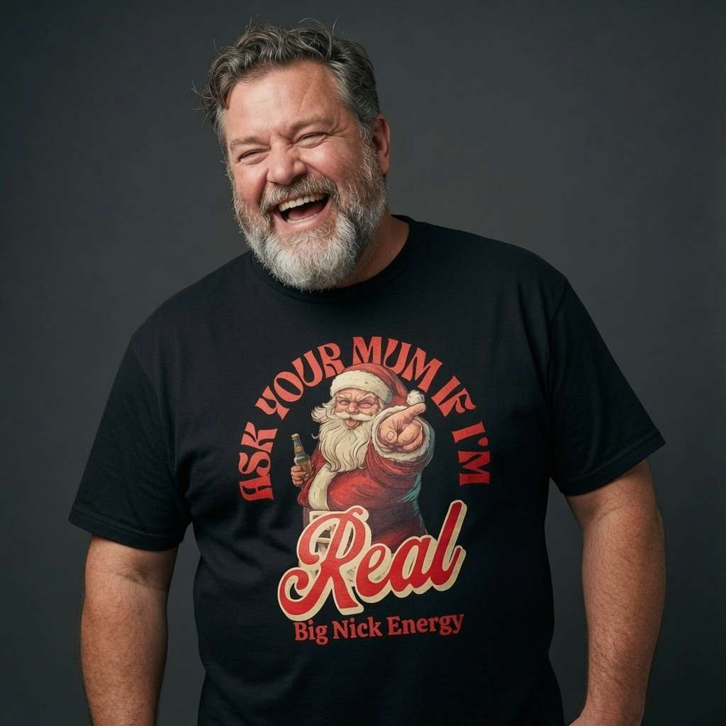 Bearded man laughing in a black Ask Your Mum If I’m Real – Big Nick Energy t-shirt, funny mens cheeky Santa banter graphic full of pure festive energy