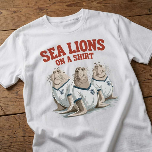 White Sea Lions on a Shirt t-shirt laid flat on a wooden surface showing the full three sea lions graphic, cheeky fun England football three lions pun design
