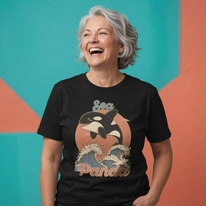Woman laughing while wearing a black Sea Panda t-shirt, witty ladies fun orca whale graphic design full of pure attitude
