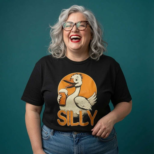 Grey-haired woman with glasses laughing in a black Silly Goose t-shirt with the full beer-drinking goose, funny ladies cheeky goose pun graphic full of pure attitude