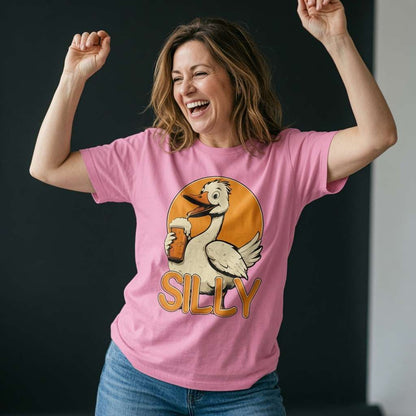 Woman laughing with both arms raised while wearing a pink Silly Goose t-shirt featuring a cartoon goose holding a pint of beer, witty ladies funny goose pun graphic