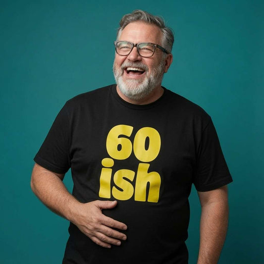 Bearded man with glasses laughing and holding his stomach in a black 60 ish t-shirt, funny 60th birthday slogan gift full of pure attitude