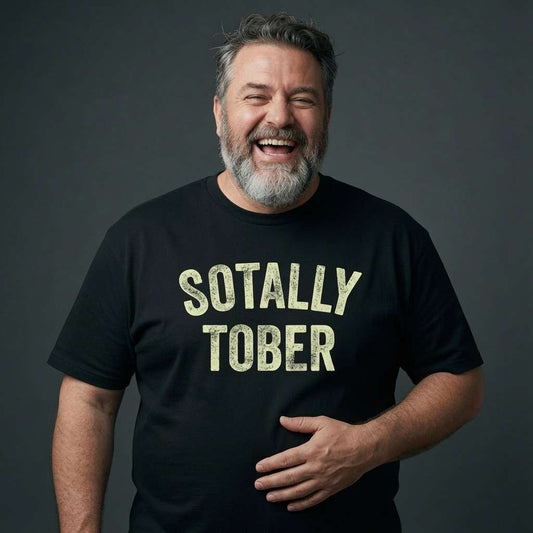 Bearded man laughing while holding his stomach in a black Sotally Tober t-shirt, funny and cheeky beer banter slogan full of pure attitude
