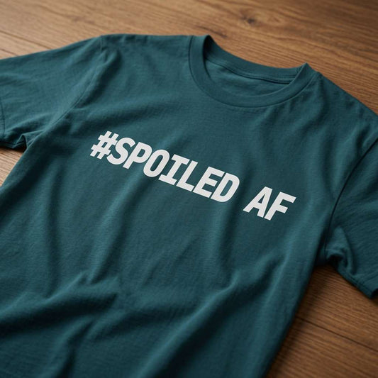 Stargazer green #Spoiled AF t-shirt laid flat on a wooden surface with bold white lettering, funny matching ladies slogan design
