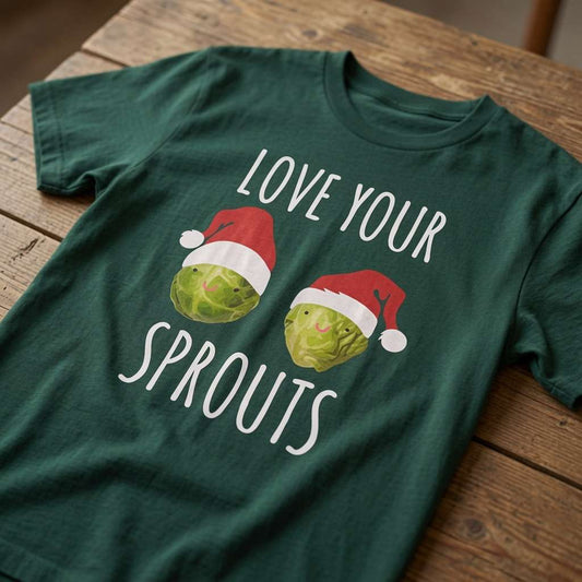 Green Love Your Sprouts t-shirt laid flat on a wooden surface featuring two smiling Brussels sprouts in Santa hats, fun and cheeky mens xmas dinner pub graphic