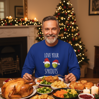 Man in a blue sweater with Christmas decorations and a Christmas tree in the background