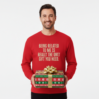 Man wearing a red sweater with humorous text holding a gift box on a white background