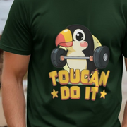 Green bird t-shirt with a cute cartoon toucan lifting weights and 'Toucan Do It' text.