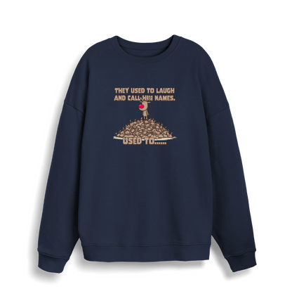 navy christmas sweater with the graphic of rudolph stood on top of a pile of reindeer and the slogan 'they used to laugh and call him names used to... '