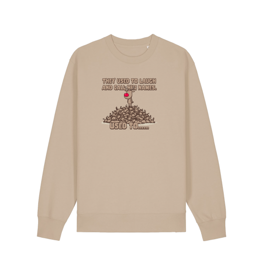 sand christmas sweater with the graphic of rudolph stood on top of a pile of reindeer and the slogan 'they used to laugh and call him names used to... '