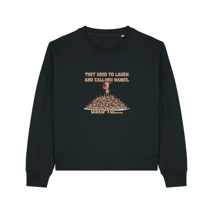 black christmas sweater with the graphic of rudoph stood ontop of a pile of reindeer and the slogan 'they used to laugh and call him names used to ..'