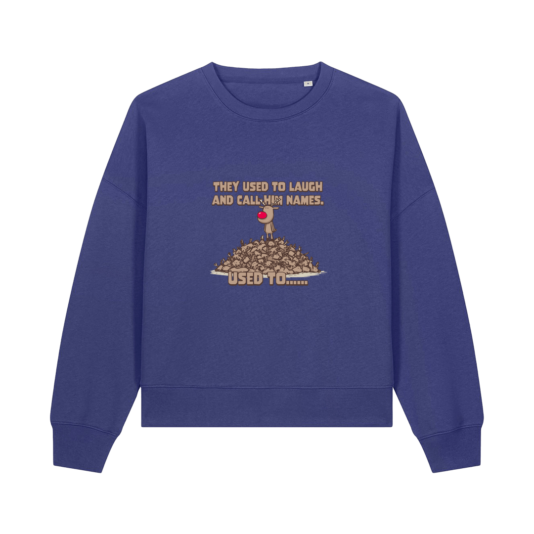 blue christmas sweater with the graphic of rudoph stood ontop of a pile of reindeer and the slogan 'they used to laugh and call him names used to ..'