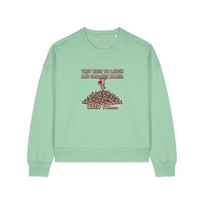 green christmas sweater with the graphic of rudoph stood ontop of a pile of reindeer and the slogan 'they used to laugh and call him names used to ..'
