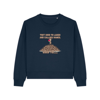 navy christmas sweater with the graphic of rudoph stood ontop of a pile of reindeer and the slogan 'they used to laugh and call him names used to ..'