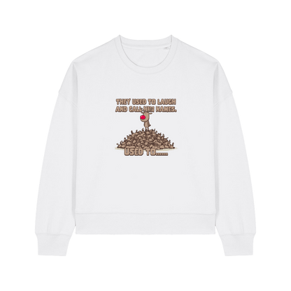 white christmas sweater with the graphic of rudoph stood ontop of a pile of reindeer and the slogan 'they used to laugh and call him names used to ..'