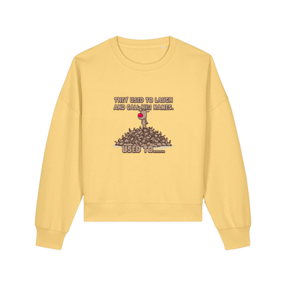 yellow christmas sweater with the graphic of rudoph stood ontop of a pile of reindeer and the slogan 'they used to laugh and call him names used to ..'