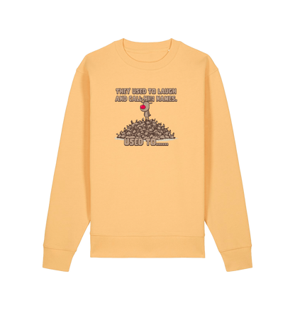 yellow christmas sweater with the graphic of rudolph stood on top of a pile of reindeer and the slogan 'they used to laugh and call him names used to... '