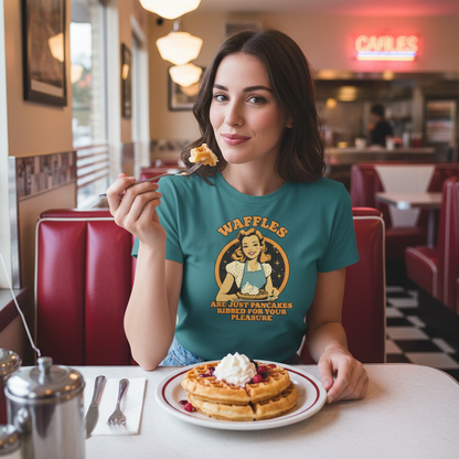 Woman in a diner wearing a t-shirt with a waffle design, eating waffles.