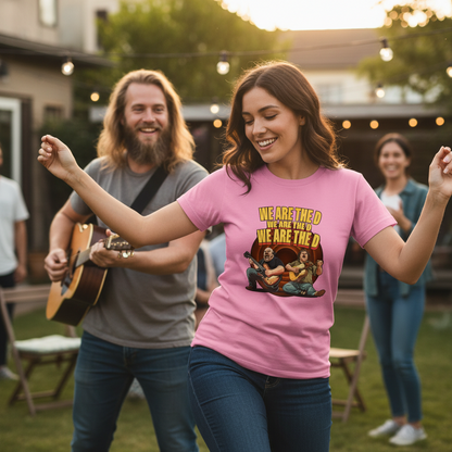 Woman in pink t-shirt dancing outdoors with a man playing guitar, surrounded by people in a casual setting.
