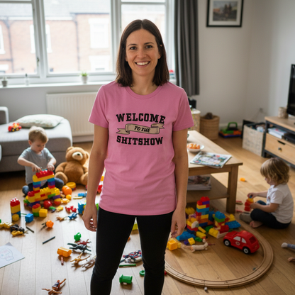 Woman wearing a pink t-shirt with text in a room with children playing toys.