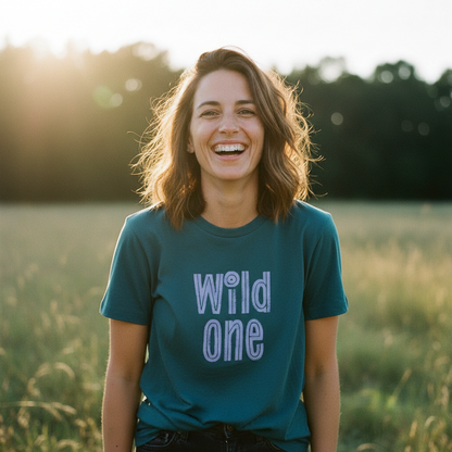 Woman wearing a teal t-shirt with 'Wild One' text in a field
