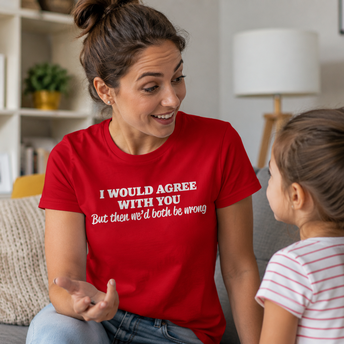 Woman in a red shirt talking to a child in a living room.