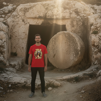 Man wearing a red t-shirt with a graphic design standing in front of ancient stone structures.