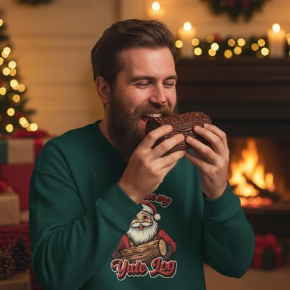Man in a festive sweater eating a chocolate donut with a Christmas tree and fireplace in the background